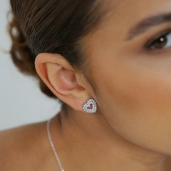 Brinco pequeno, banhado a Ouro 18k ou Ródio Branco, em formato de coração, cravejado com zircônias. 