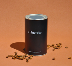 Lata de la marca Chiquitito Café de 250grs, con granos de café esparcidos alrededor.