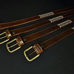Cinturones bordados con hebilla de bronce .