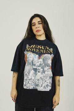Camiseta Jesus Movement. Cristã, unissex, modelo oversized e na cor preta.  A estampa mostra os grandes momentos do avivamento da década de 70