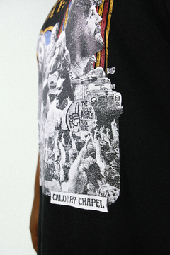 Camiseta Jesus Movement. Cristã, unissex, modelo oversized e na cor preta.  A estampa mostra os grandes momentos do avivamento da década de 70