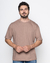 Camiseta oversized de algodão na cor marrom, modelo masculino, em fundo neutro.