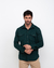 Homem usando uma jaqueta overshirt verde, com bolsos frontais e botões, em fundo branco.