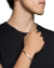 Homem usando um bracelete oval em prata 925 no pulso, com camisa preta e fundo neutro.