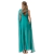 Mulher de costas vestindo um vestido longo verde com capa, cabelo solto e adornos dourados nos braços.
