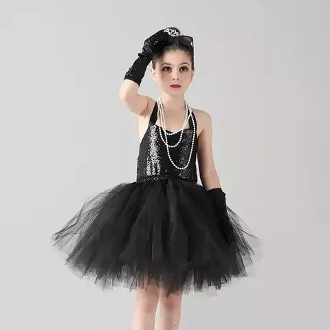 Menina vestida com fantasia de anos 80, usando vestido preto com tule e acessórios como luvas e pérolas.