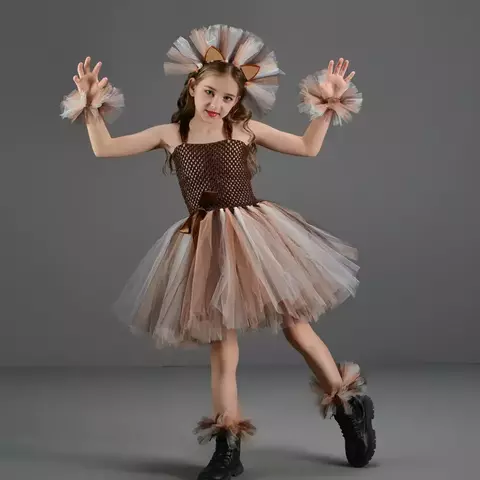 Menina vestindo fantasia de leão com acessórios, incluindo tiara e punhos de tule.