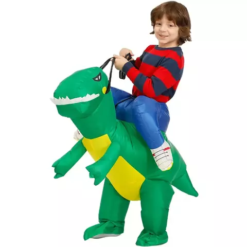 Criança feliz vestindo fantasia inflável de dinossauro, montada em um dinossauro verde.