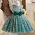 Vestido de princesa infantil em tons verdes com lantejoulas douradas e laço verde na cintura.