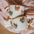 Tazas mariposas en vuelo, fondo blanco