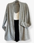 Cardigan de malha tricô cinza mescla, com bolso e punho duplo  , com blusa branca e calça preta 