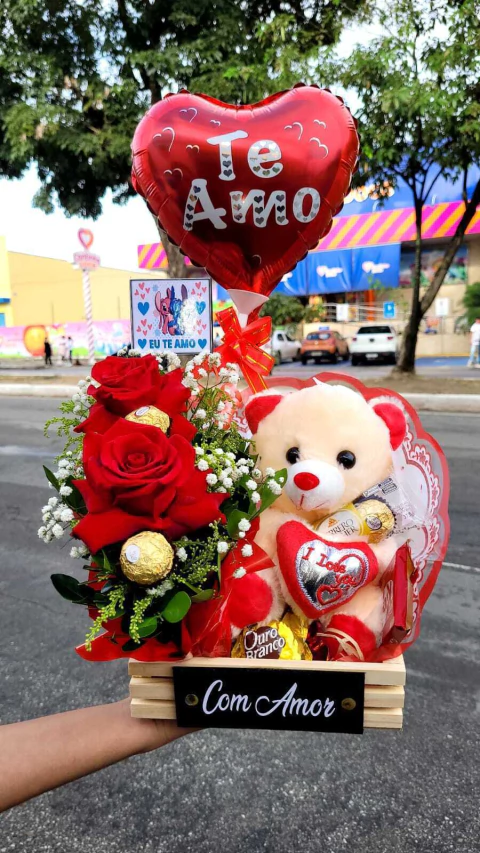CESTA ROMÂNTICA(cesta , arranjo com 2 rosas com 2 unidades de ferrero, 3 sonho de valsa,1 kitket, 1 pacote T3 de ferrero, 1 urso pequeno , 1 balão , 1