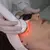 Tratamento facial com aparelho Beauty Steam Maxx IoT emitindo luz LED vermelha no rosto de mulher usando óculos de proteção. D&D Estética e Saúde