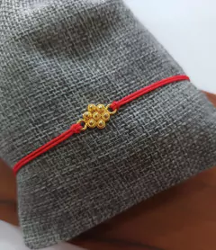 Pulsera hilo rojo flor de tomatillo con baño en oro