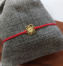 Pulsera hilo rojo flor con caracoles con baño en oro