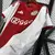 Camisa titular do Ajax 2025/26 com listras vermelha e branca, patrocinador Ziggo, escudo com três estrelas e detalhes da Adidas