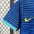 Camisa azul reserva da Seleção Brasileira feminina 2024, modelo Nike com gola em verde claro, escudo da CBF com cinco estrelas e design ondulado moderno em tons de azul