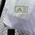 Camisa reserva Manchester United 2025/2026 masculina branca Adidas, modelo oficial com escudo Manchester United em roxo, patrocínio Snapdragon em roxo e detalhes em roxo e preto, para torcedores.