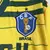 Camisa retrô titular amarela da Seleção Brasileira 1984 masculina Topper, modelo oficial com escudo CBF grande, detalhes verdes e listras, para colecionadores e torcedores.