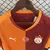 Camisa titular Galatasaray 2025/2026 masculina Puma, modelo oficial com design meio a meio em laranja e vinho, escudo do clube e estrela turca, para torcedores.
