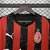 Camisa titular AC Milan 2025/2026 masculina Puma, modelo oficial com listras verticais em preto e vermelho, escudo AC Milan, patrocínio Emirates, para torcedores.