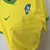 Camisa amarela titular da Seleção Brasileira 2023, modelo Nike com gola em verde, escudo da CBF redesenhado e acabamento clean, estilo clássico e moderno