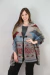 Pashmina con diseño geométrico en tonos marrones, azules y rojos, usada por una mujer que sonríe.