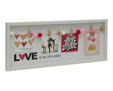 Portarretratos con broches que muestra fotos y mensajes decorativos sobre un fondo blanco.