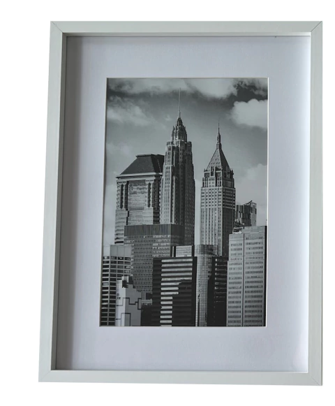 Portarretratos decorativo blanco con una imagen en blanco y negro de edificios de una ciudad.