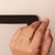 Anel longo negro delicado em uma mão feminina