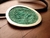 Colar com pingente oval em prata, com superfície verde texturizada.
