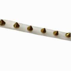 Galón (cinta) con púas doradas.