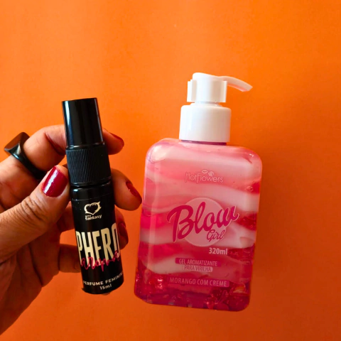 Frasco de perfume feminino Phero Fantasy e gel aromatizante Blow Girl morango com creme, sobre fundo laranja.