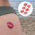 Tatuagem temporária de marca de beijo vermelha aplicada na pele de uma pessoa na praia