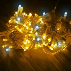 Fios de pisca pisca com 100 LEDs em cores amarelas e brancas, enrolados em um fundo escuro.