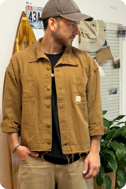 Hombre vistiendo una campera unisex Hana color tostado con botones metálicos y borde inferior desflecado