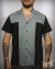 Camisa bowling estilo americana,  em tons de cinza e preto, com detalhes em costura, usada por um homem tatuado.