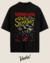 Camiseta oversized inspirada no livro "Pet Sematary" de Stephen King, com estampa de um gato preto e detalhes em vermelho e amarelo.