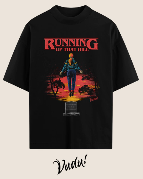 Camisa oversized preta com estampa inspirada em filmes de horror e Stranger Things, apresentando a personagem Max com a frase "RUNNING UP THAT HILL" e uma figura em um cenário sombrio.