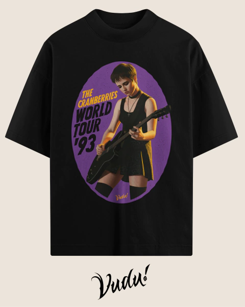 Camiseta preta oversized com estampa da turnê mundial de 1993 da banda The Cranberries, mostrando uma mulher tocando guitarra em fundo roxo