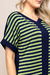 Detalhe de um vestido visco listrado em verde e azul marinho, com mangas curtas e decote em V.