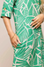 Detalhe do vestido chemise em visco crepe estampado em verde, com padrão de folhas, botões na manga e bolso na lateral.