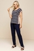 Look feminino moderno e elegante de blusa visco listrada com listras azul e bege, combinada com calças marinho.