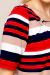 Detalhe de uma blusa feminina de verão listrada em tons de vermelho, azul marinho e bege, com mangas curtas e decote arredondado com argola.