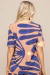 Blusa Wave Estampada com estampa colorida em fundo claro, vista de costas, com mangas curtas.