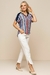 Modelo usando blusa visco crepe estampada com listras coloridas e calça de jacquard, um look de verão moderno e elegante.