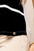 Detalhe de uma blusa visco crepe listrada nas cores preta e branca, com destaque para um rebite dourado na barra.