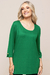 Modelo usando blusa verde de visco crepe com mangas 3/4 e detalhe em botão.