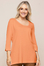 Modelo usando blusa laranja de visco crepe com mangas 3/4 e detalhe em botão.