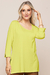 Modelo usando blusa verde neon de visco crepe com mangas 3/4 e detalhe em botão.